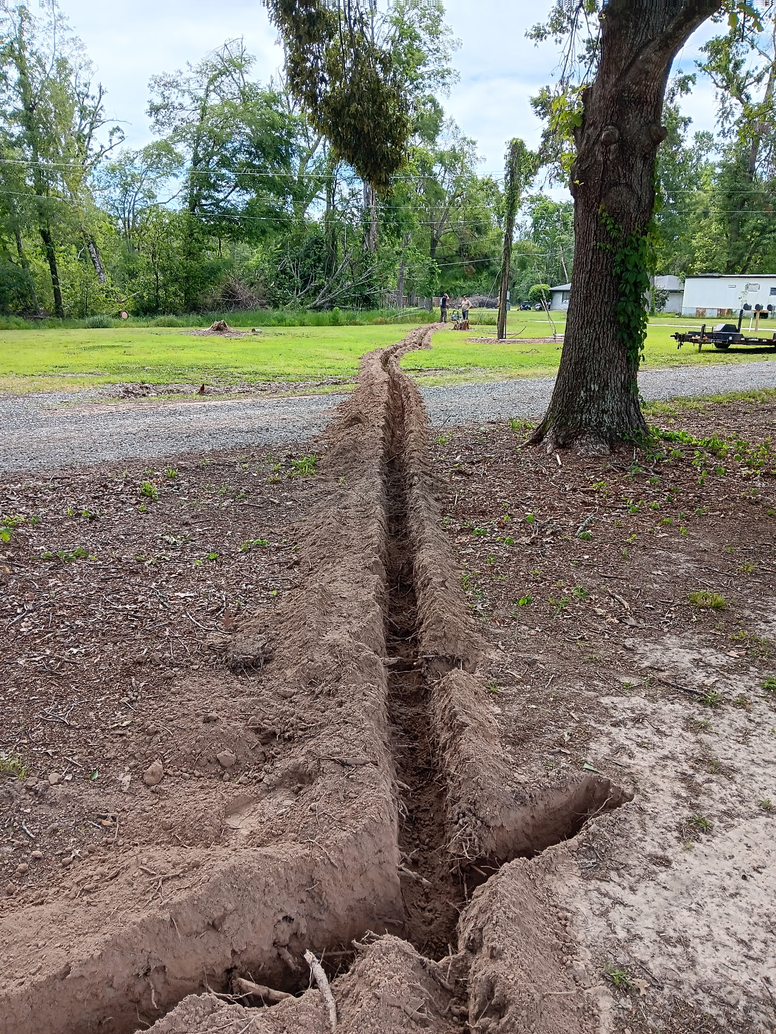 Trench running across gravel road to home, McKinney, TX