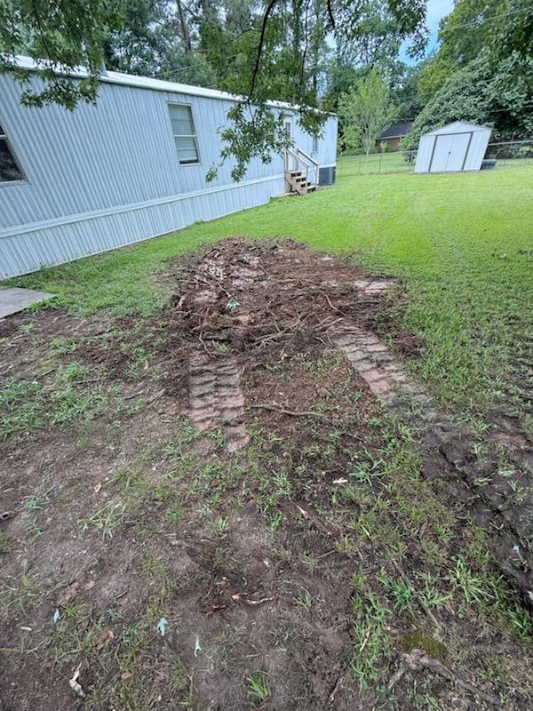 Wide view of excavated trench run beside mobile home at RV park, near Dallas, TX